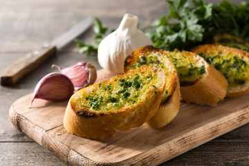 Garlic breads slice and ingredients on wooden table.
