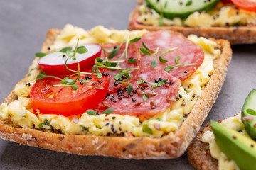 Sandwiches with cream cheese, vegetables and salami.