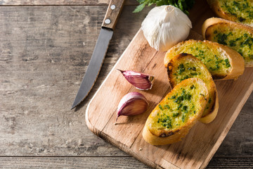 Garlic breads slice and ingredients on wooden table. Top view. Copyspace