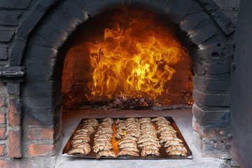 Steinofen mit Backblech und großem Feuer