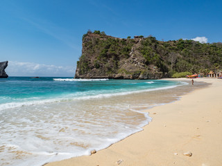 The Atuh beach, Nusa Penida island near Bali, Indonesia. Ocean waves, cliffs and a desert beach with tropical plants. October, 2018