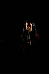 Woman singer singing a song in the recording studio.