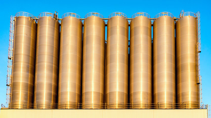 Chemical plant, containers . Storage tanks for petroleum products. Equipment refinery . White tanks for petrol and oil in tank farm with blue sky .