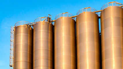 Chemical plant, containers . Storage tanks for petroleum products. Equipment refinery . White tanks for petrol and oil in tank farm with blue sky .