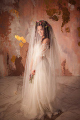 Beautiful young bride in wedding dress with veil on her face