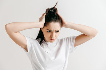 Woman having headache. Isolated on gray background. Businesswoman standing with pain isolated on...