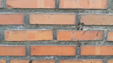 Fototapeta premium A background of a weathered old exterior brick wall in the sunshine.