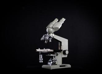white medical microscope isolated on black background