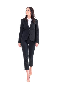 Successful Elegant Business Woman In Black Suit Walking And Looking Away. Full Body Isolated On White Background.