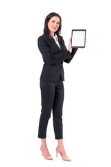 Satisfied smiling elegant business woman in suit showing and presenting tablet application. Full body isolated on white background.