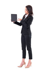 Confident elegant business woman showing blank black pad display. Full body isolated on white background.