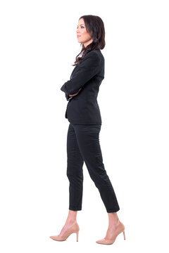 Side View Of Business Woman With Crossed Arms Walking, Smiling And Looking Away. Full Body Isolated On White Background.