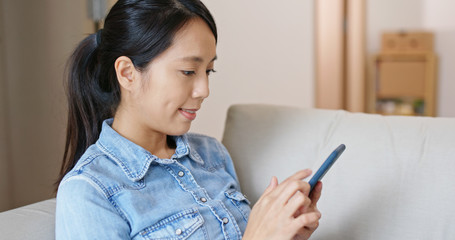 Woman use of mobile phone on sofa