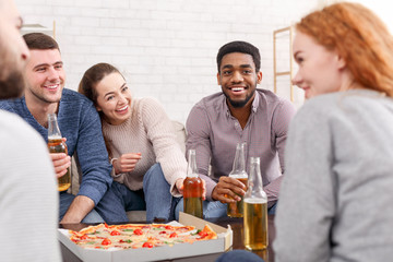 Friends talking, eating pizza and drinking beer