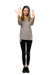 Obraz premium A full-length shot of a Young woman with headscarf counting seven with fingers over isolated white background