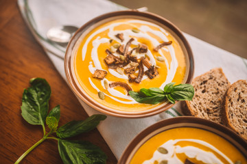  tasty autumn coconut pumpkin cream soup bowl with tofu, caramelized onion and seeds
