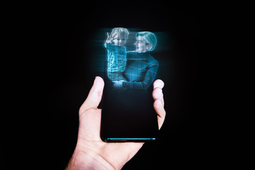hologram of a child and grandmother displayed on a smartphone held by an hand.  future connectivity, next communication, family relationship concept  - obrazy, fototapety, plakaty