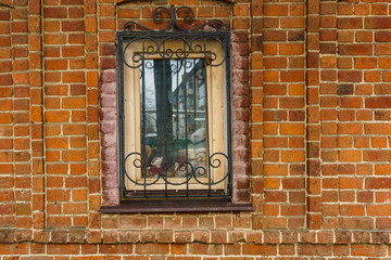 Fototapeta na wymiar window in a red brick house with a lattice