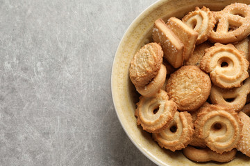 Bowl with Danish butter cookies on grey background, top view. Space for text