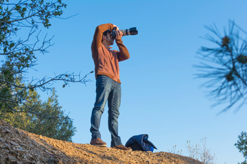 Man taking photos in the mountain with a zoom