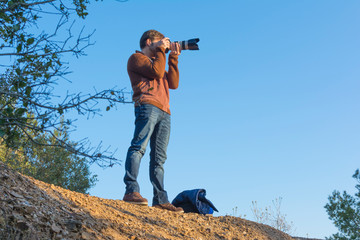 Man taking photos in the mountain with a zoom
