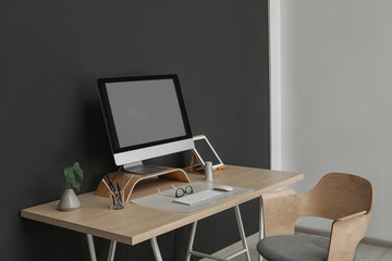 Fototapeta premium Modern workplace interior with computer on table. Space for text