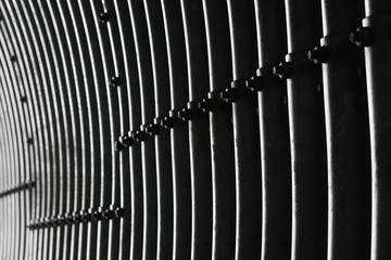 metal interior of the tunnel, abstract detail with dark and bright lines, texture interspersed with screws and nuts