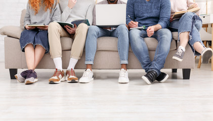 Students preparing for exam, sitting on sofa