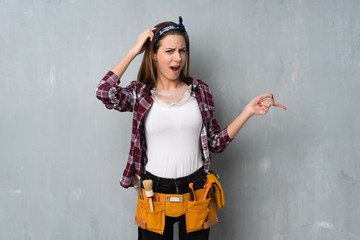 Craftsmen or electrician woman surprised and pointing finger to the side