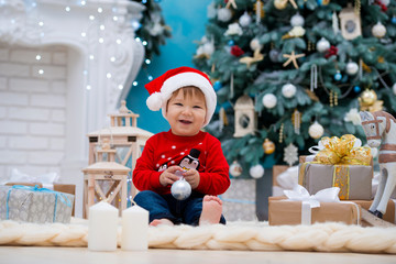 little baby santa claus in christmas hat. Happy new year and merry christmas. Holidays and gifts for children