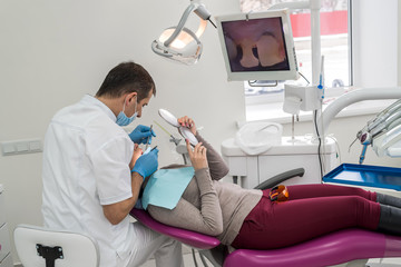 Doctor showing to patient teeth problems in mirror