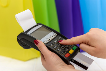 Female hand pressing buttons on terminal with card