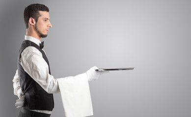 Waiter serving with white gloves and steel tray in an empty space
