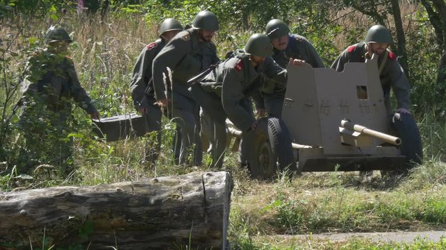Soldiers moving a anti tank gun in a fire position