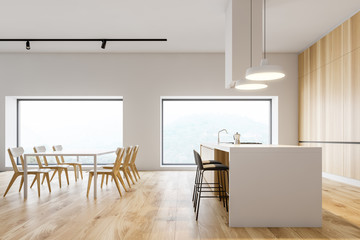 Side view of white and wood kitchen, bar and table