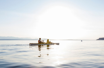 People couple having fun sea kayaking. Active summer outdoor adventure water sports.