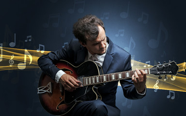 Young male musician playing on his guitar with musical notes around