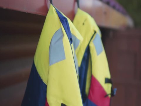 Watersport adventure - colorful life vests hanging on the nail