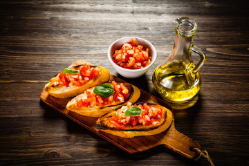 Bruschettas on cutting board on wooden background