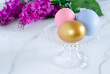 Colorful easter eggs on glass pedestal.