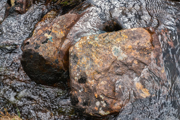 Stones in running water in a mountain river stream