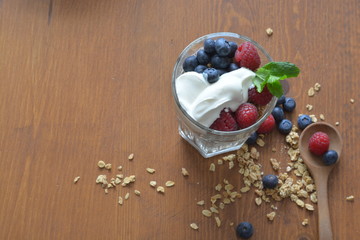 granola in a glass with greek yoghurt, raspberries and blueberries