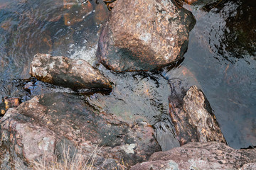Stones in running water in a mountain river stream