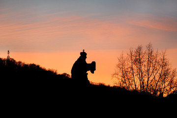 Sights of Prague, Czech Republic. Beautiful landscape silhouettes of sculptures against sky. Sunset backlit silhouettes of statues and roofs on hill background of cityscape skyline at Charles Bridge.