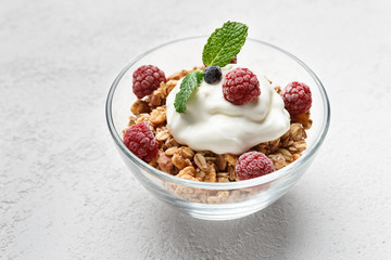 Granola, yougurt and raspberries in bowl