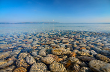 Calm seaside reflection of stones in water at the beach