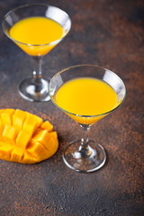 Tropical cocktail with mango on dark background