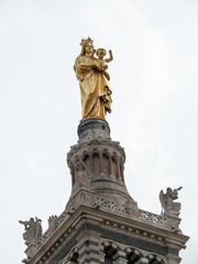 Fototapeta premium Belfry, bell tower and statue of the Virgin with child at Notre-Dame de la Garde (literally: Our Lady of the Guard) is a Catholic basilica in Marseille, France.