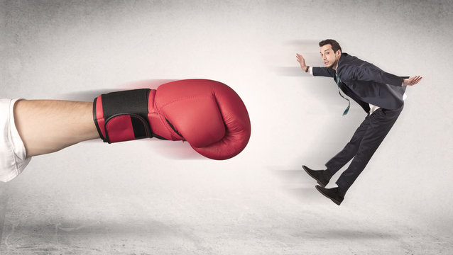 Businessman gets fired from his job by a huge hand in boxing gloves