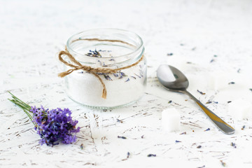 Glass jar with lavender sugar, fresh lavender on a light wooden background